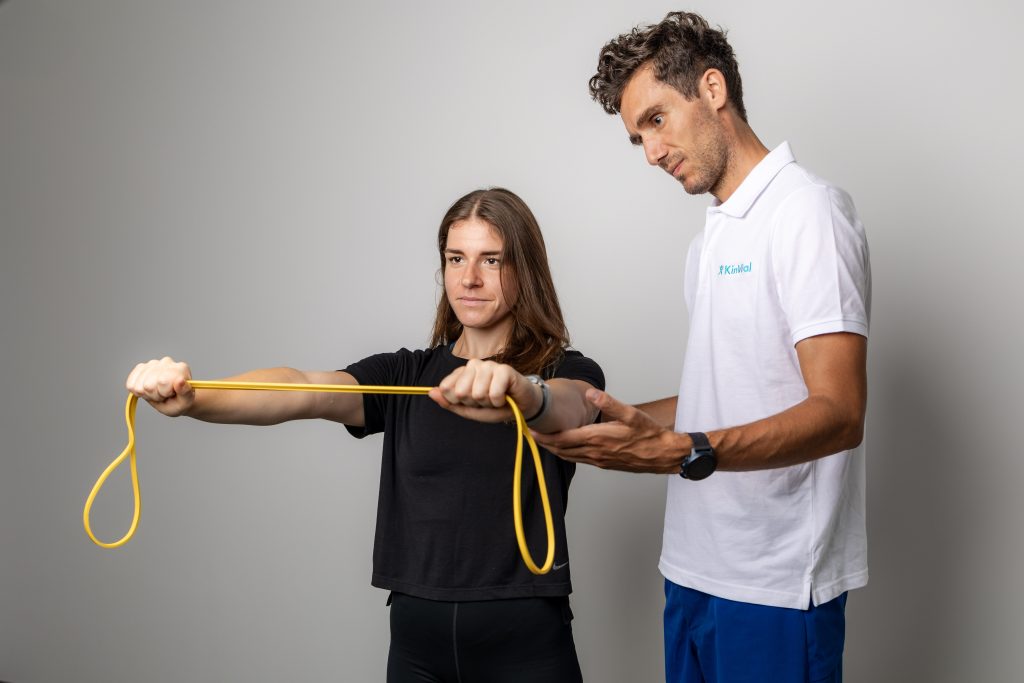 Ženska izvaja vajo z elastiko pod nadzorom strokovnjaka