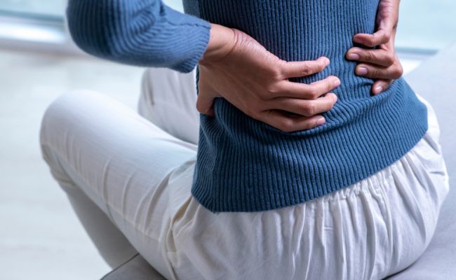 dekle, ki ima bolečine v križu.